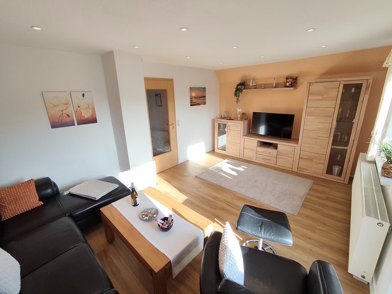 Heller Wohnbereich mit Ledergarnitur, Couchtisch und TV-Wand